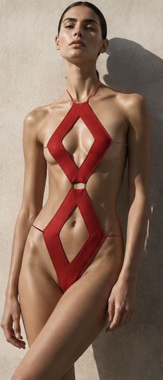 A model in the red RHOMBOS one-piece, two open diamonds linked at the centre.